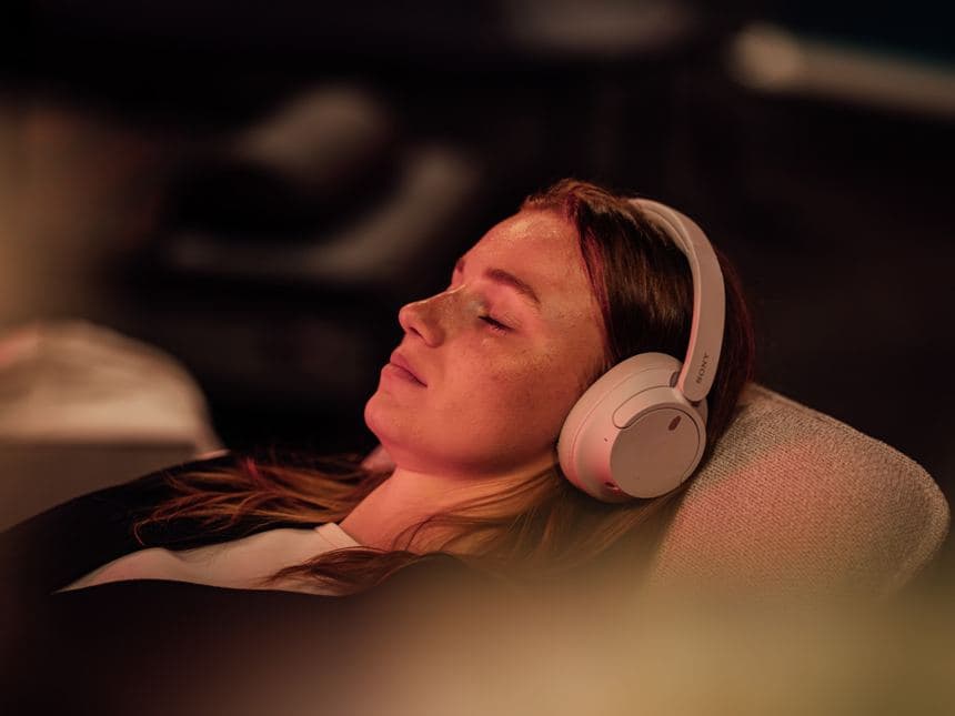 Žena se sluchátky odpočívá v relaxační zóně, ročník 2026